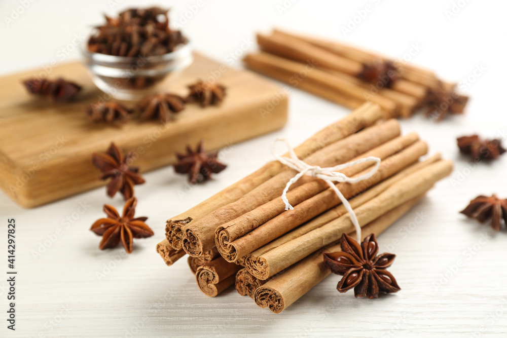 Aromatic cinnamon sticks and anise on white wooden table Aromatic cinnamon sticks and anise on white wooden table