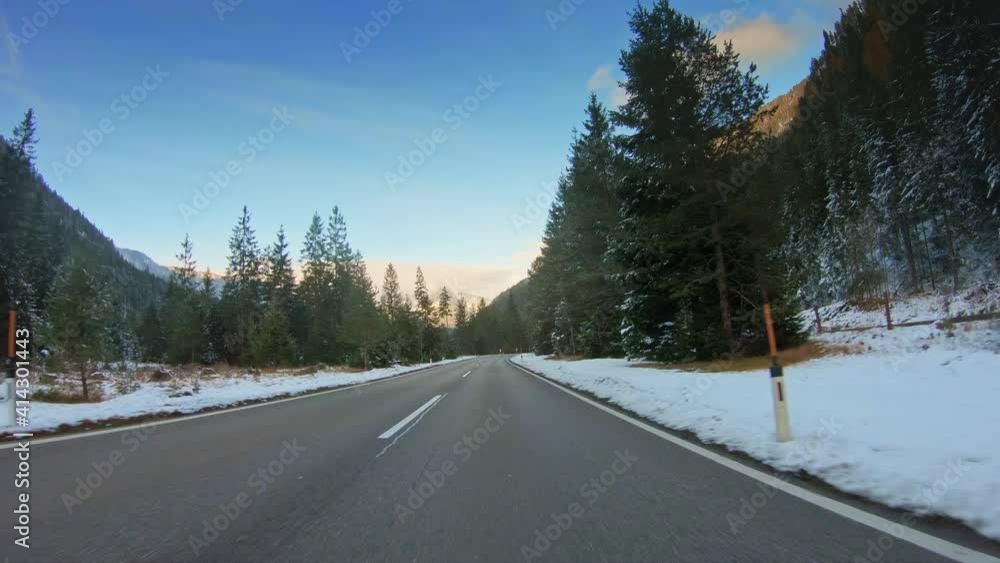 POV vehicle driving alongside railroad, gopro car travel point of view on beautiful countryside winter nature with pristine forest evergreen trees, snow and blue sky, curvy asphalt road POV vehicle driving alongside railroad, gopro car travel point of view on beautiful countryside winter nature with pristine forest evergreen trees, snow and blue sky, curvy asphalt road