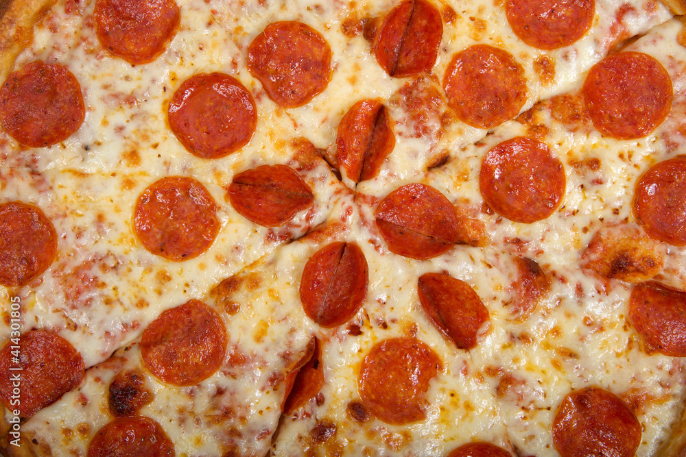 Top view flat lay of one whole sliced pepperoni pizza in the box. Close up. Top view flat lay of one whole sliced pepperoni pizza in the box. Close up.