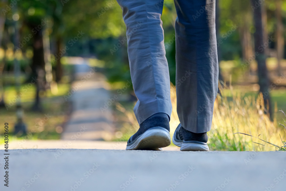 Feet walking on the walkway in the park Feet walking on the walkway in the park