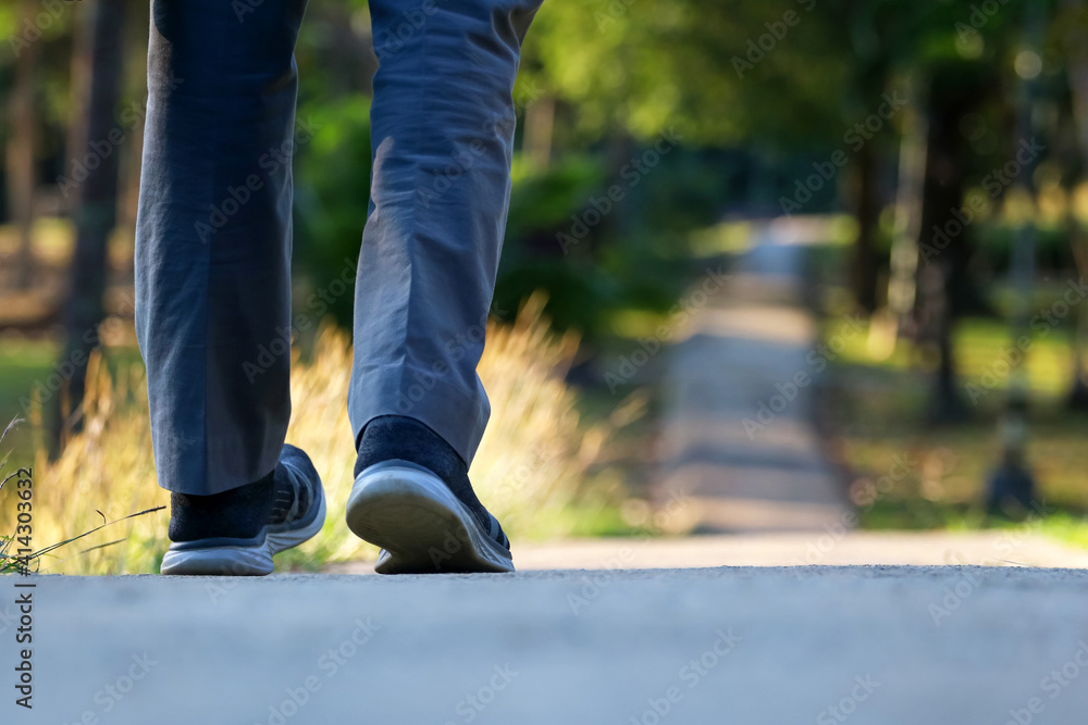 Feet walking on the walkway in the park Feet walking on the walkway in the park