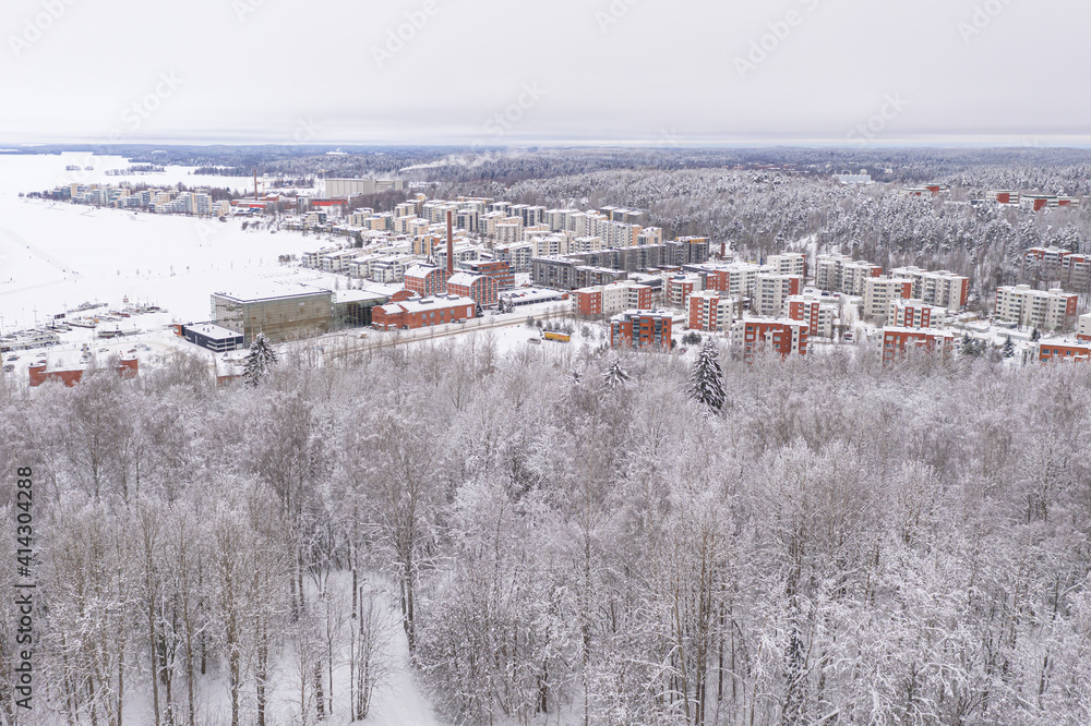 Lahti, Finland February 14, 2021. Photo from the drone. City view, residential buildings and streets covered in snow, partly forested area. The day is cloudy, winter