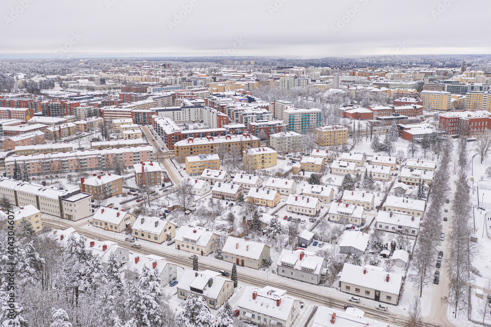 Lahti, Finland February 14, 2021. Photo from the drone. City view, residential buildings and streets covered in snow, partly forested area. The day is cloudy, winter