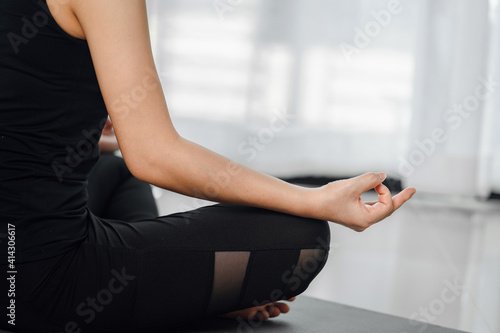 close up of sideview, young woman practicing yoga lesson, half Lotus pose with mudras gesture, breathing exercises, meditation.