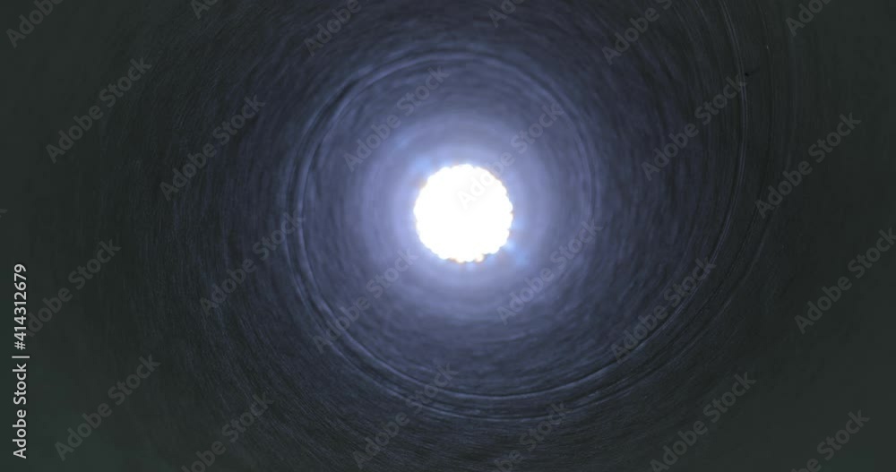 Moving through a tube tunnel with bright light shining at the end, probe lens motion, rising in shaft