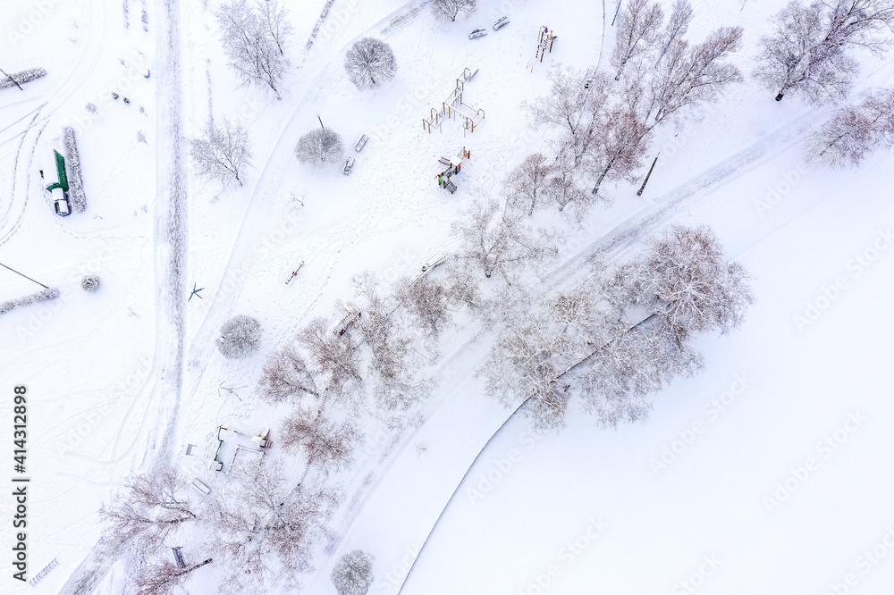 Fototapeta premium winter park landscape. empty playground covered with snow. top view aerial photo from flying drone