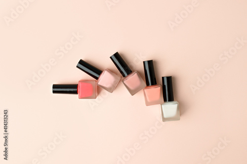 Set of nail polish bottles neutral natural colors on beige background. Concept of pallete for french manicure, woman beauty cosmetology, handcare, beautician industry photo