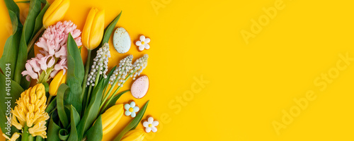Easter floral background, various gingerbread glazed cookies end decorated with natural botanical elements on yellow, flat lay, view from above, blank space for greeting text, banner, flyer, coupon