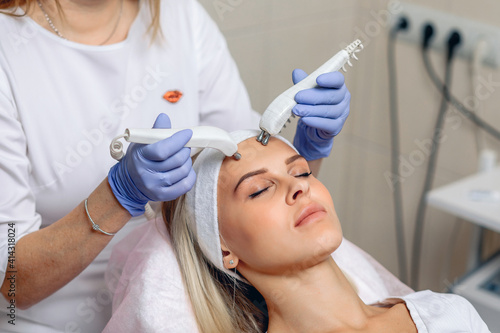 Microcurrent therapy for a lovely young and charming client enjoying the procedure. Beauty salon. Concert of cosmetic procedures
