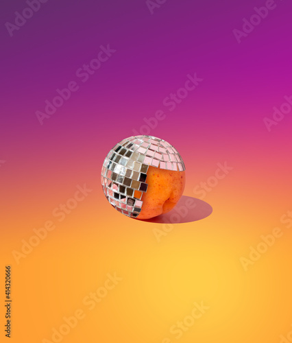 Fotografie, Tablou Peach in a disco ball on a yellow-pink gradient background