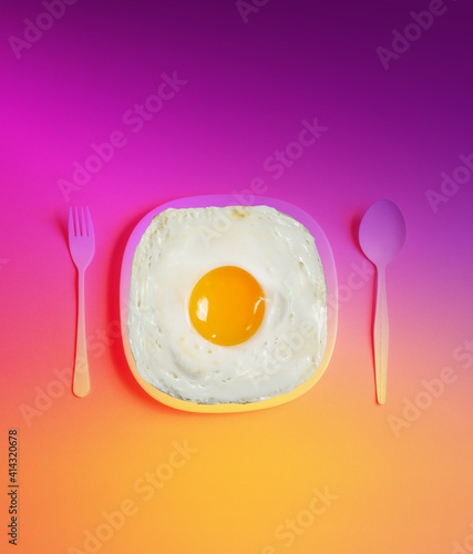 Funny fried eggs on a yellow-pink gradient background. The concept of a good day and mood