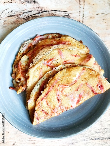traditional Russian pancakes with ham on a plate.