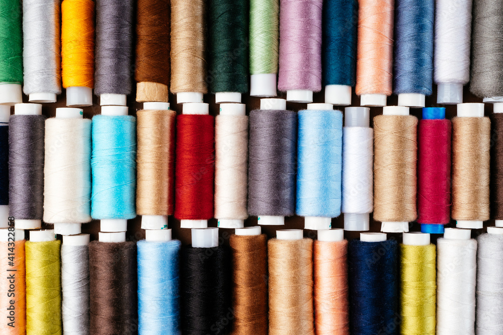 Many different reels with threads, flat lay, top view. Colored threads, close-up, bright background. Cutting and sewing clothes concept. Accessories for needlework Many different reels with threads, flat lay, top view. Colored threads, close-up, bright background. Cutting and sewing clothes concept. Accessories for needlework