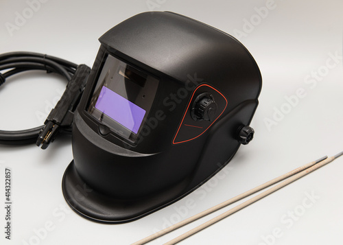 Inverter welding machine, welding equipment, on a gray background, welding mask, welding electrodes, high-voltage wires with clamps, a set of accessories for arc welding.