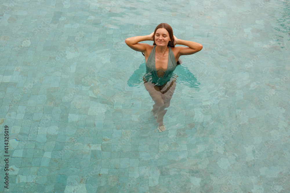 Portrait beautiful young caucasian woman relax in  swimming pool in hotel resort for leisure in vacation, closed eyes