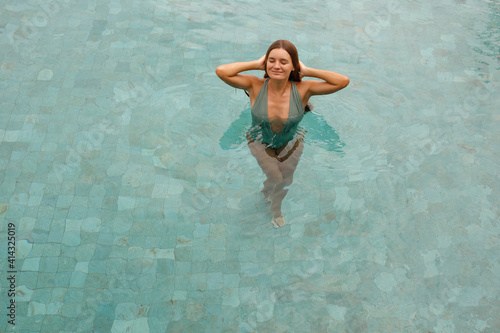 Portrait beautiful young caucasian woman relax in swimming pool in hotel resort for leisure in vacation, closed eyes