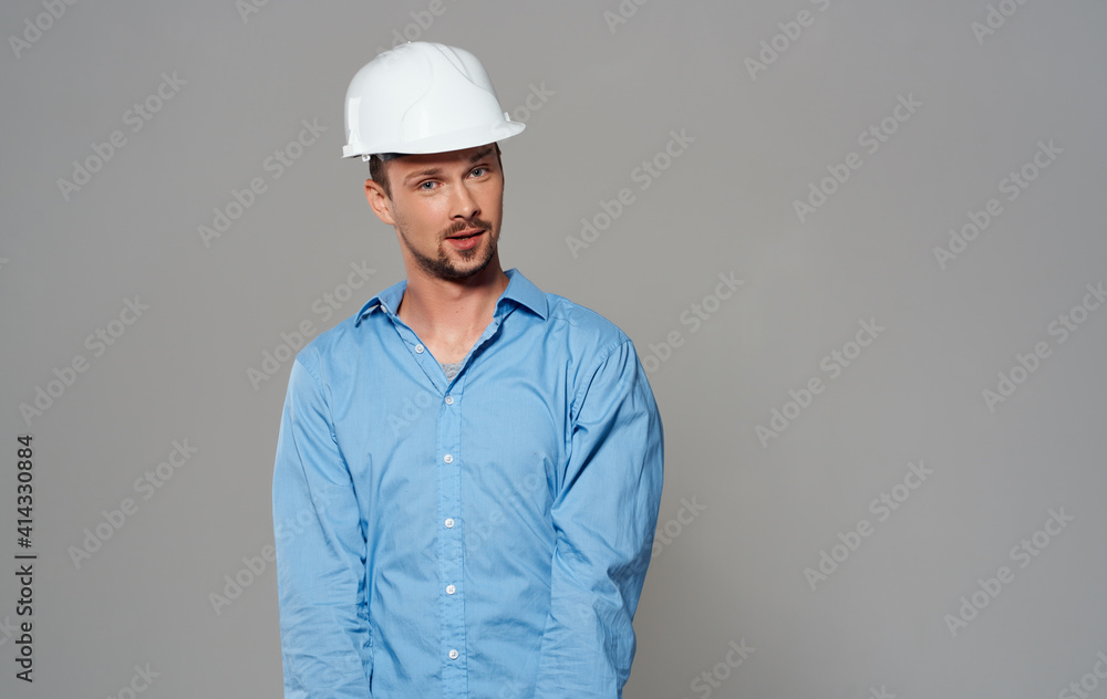 Emotional architect builder in a white helmet and in a blue shirt on an isolated background Emotional architect builder in a white helmet and in a blue shirt on an isolated background