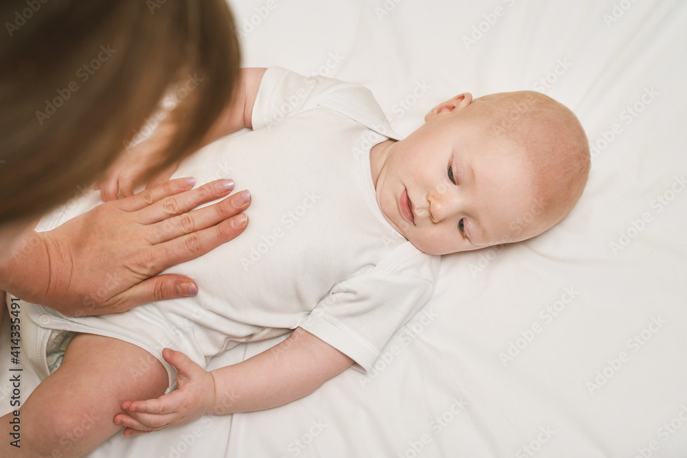 Cute small boy lying at bed. Childhood concept. Light background. Serious child. Copyspace. Stay home. Mockup. Massage. White clothes Cute small boy lying at bed. Childhood concept. Light background. Serious child. Copyspace. Stay home. Mockup. Massage. White clothes