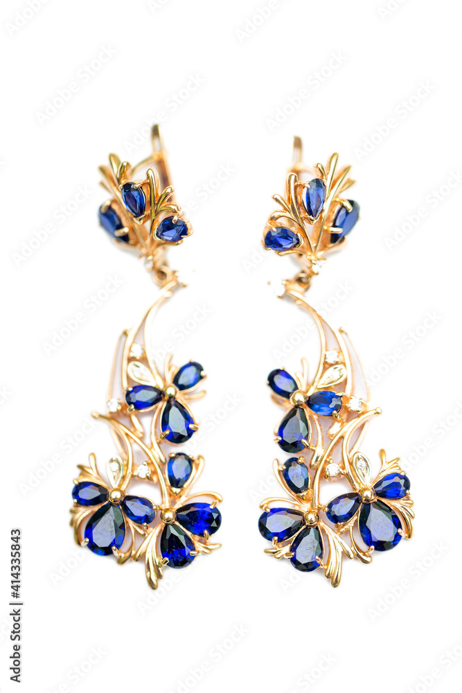 Gold earrings with blue sapphires and cubic zirkonia on a white background