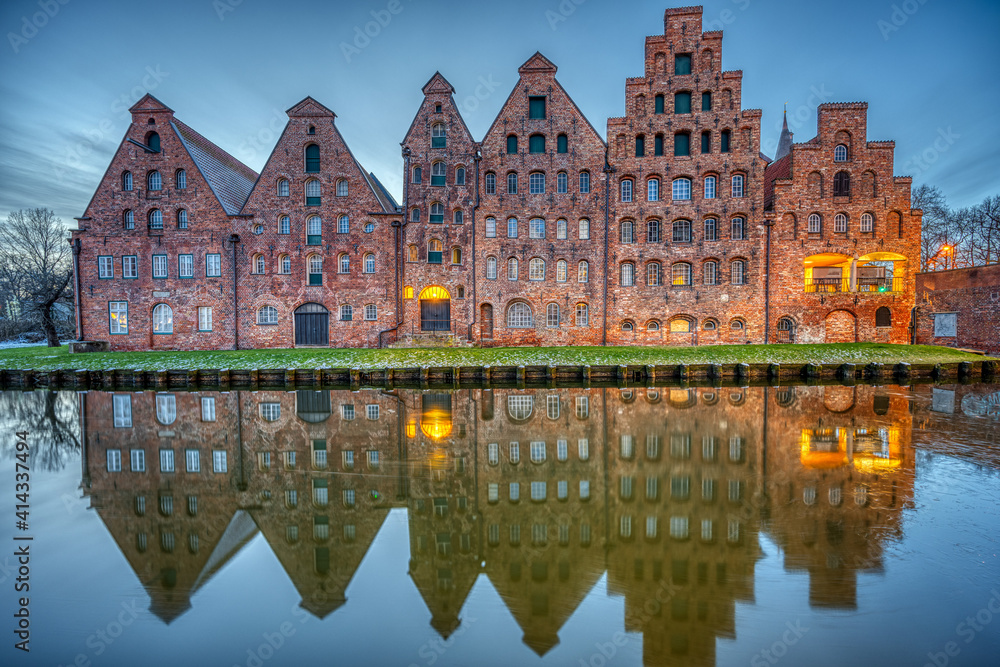 The historic Salzspeicher reflecting in the Trave river at dawn, seen in Luebeck, Germany The historic Salzspeicher reflecting in the Trave river at dawn, seen in Luebeck, Germany