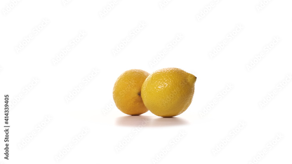 Two fresh yellow lemons are spinning on white background. Freshly picked sour cut lemons on turntable detailed view isolated. Two fresh yellow lemons are spinning on white background. Freshly picked sour cut lemons on turntable detailed view isolated.