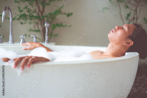 Asain man relaxing in the bathtub with foam bath. 