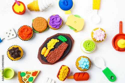 View of miniature toy kitchenware and foods on white background. Image with selective focus and flat lay.