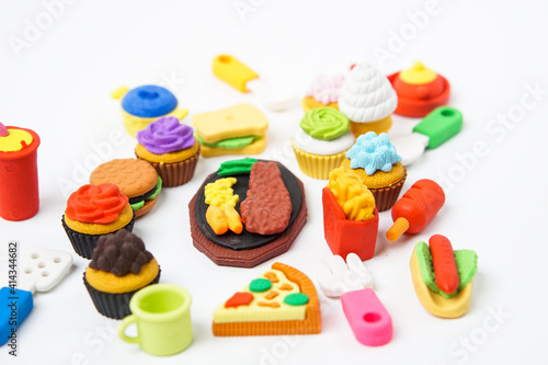 View of miniature toy kitchenware and foods on white background. Image with selective focus and flat lay.