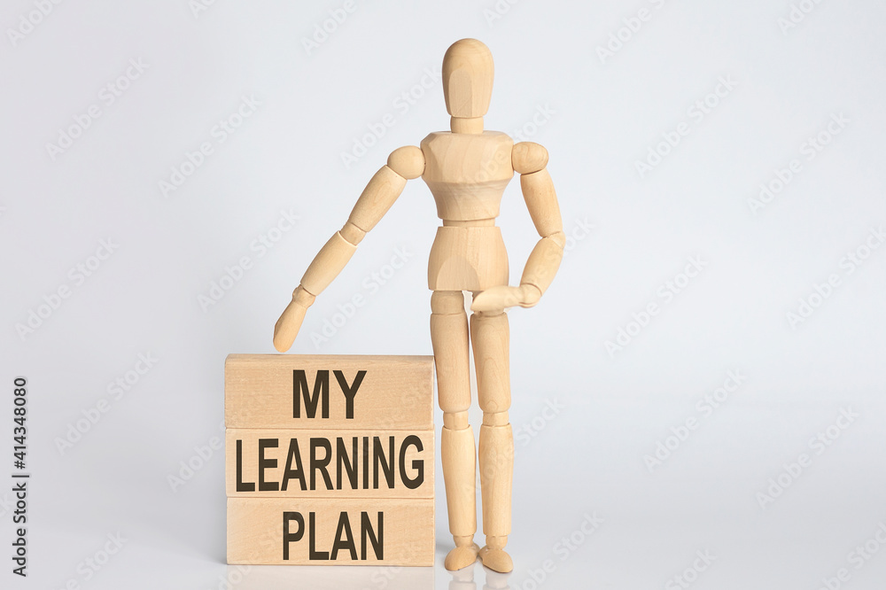 Wooden man shows with a hand text my learning plan concept on wooden block Wooden man shows with a hand text my learning plan concept on wooden block