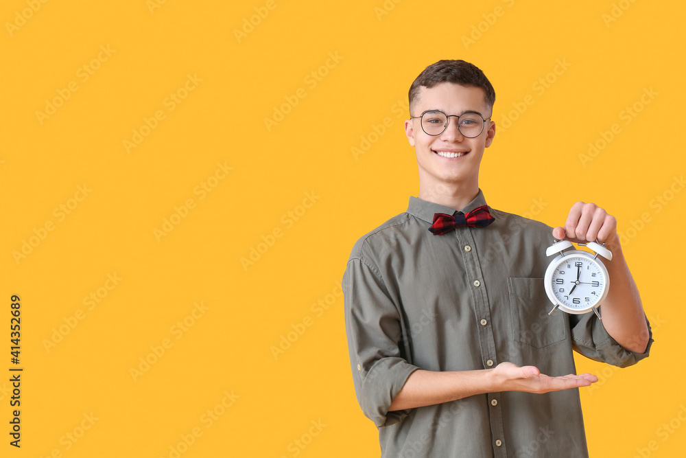 Teenager with alarm clock on color background Teenager with alarm clock on color background