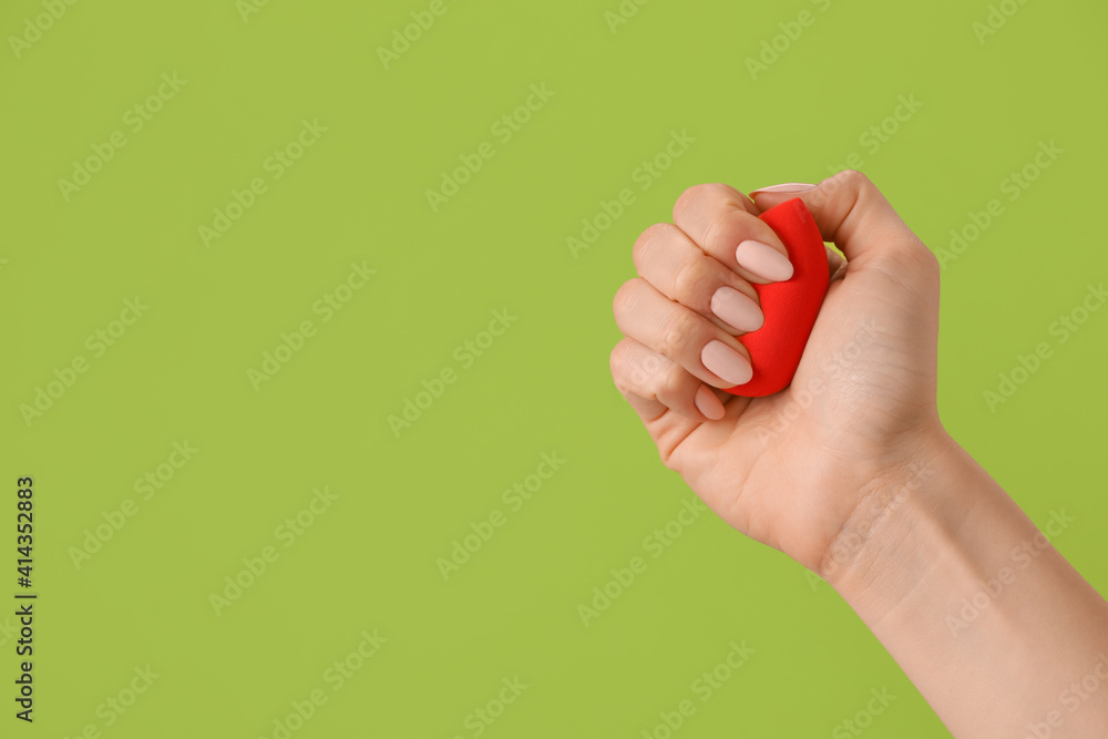 Hand with makeup sponge on color background Hand with makeup sponge on color background
