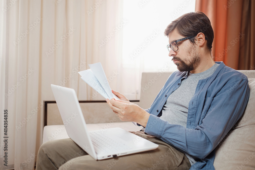 Entrepreneur works with a laptop and keeps a document in a home office Entrepreneur works with a laptop and keeps a document in a home office