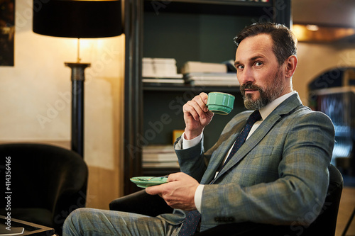 Handsome gentleman posing for camera with a cup of tea photo