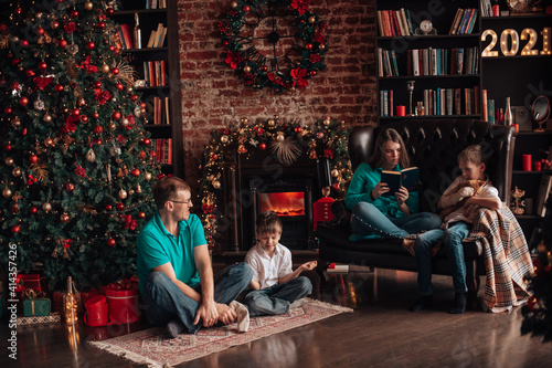 A family with three children decorates a Christmas tree © allaeliseeva