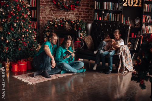 A family with three children decorates a Christmas tree