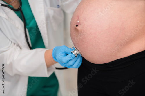 Doctor checking a pregnant woman with a stethoscope