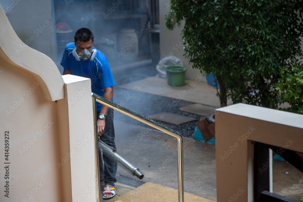 insect treatment. man in a respirator sprays smoke poison