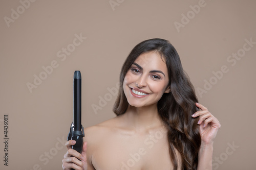 Half-naked woman with curling iron in her hand