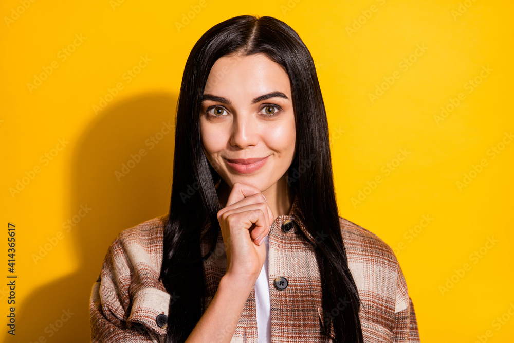 Photo of young attractive woman happy positive smile hand touch chin think isolated over yellow color background Photo of young attractive woman happy positive smile hand touch chin think isolated over yellow color background