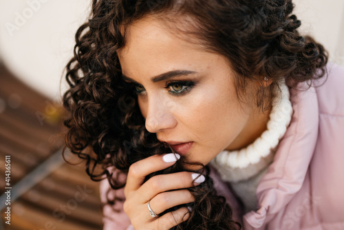 close-up. the face of a beautiful brooding girl in a half turn who looks frozen look of beautiful green eyes hanging to the lips curls of her hair. High quality photo photo