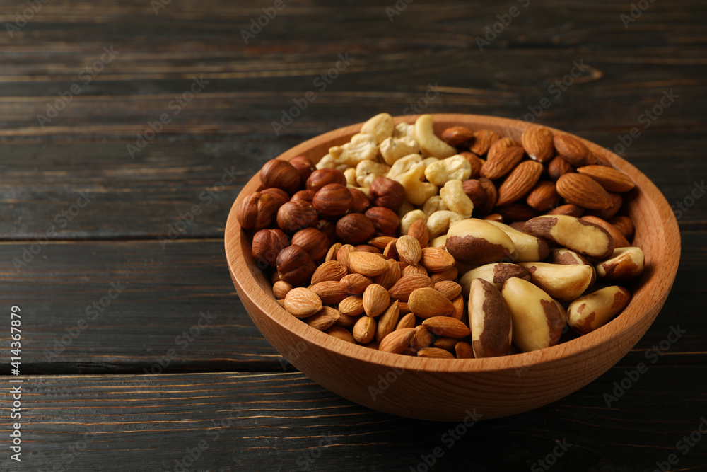 Bowl with different nuts on wooden background Bowl with different nuts on wooden background