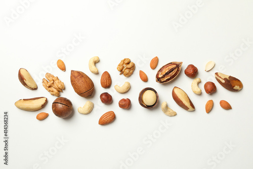 Different tasty nuts on white background, space for text