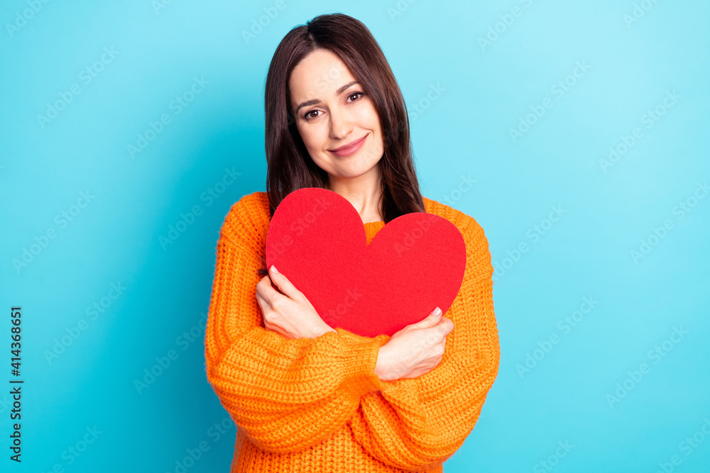 Portrait of charming positive lady arms hold embrace paper heart symbol isolated on blue color background Portrait of charming positive lady arms hold embrace paper heart symbol isolated on blue color background