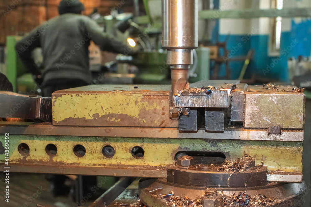 The work of the milling machine close-up. On the background of the workers The work of the milling machine close-up. On the background of the workers