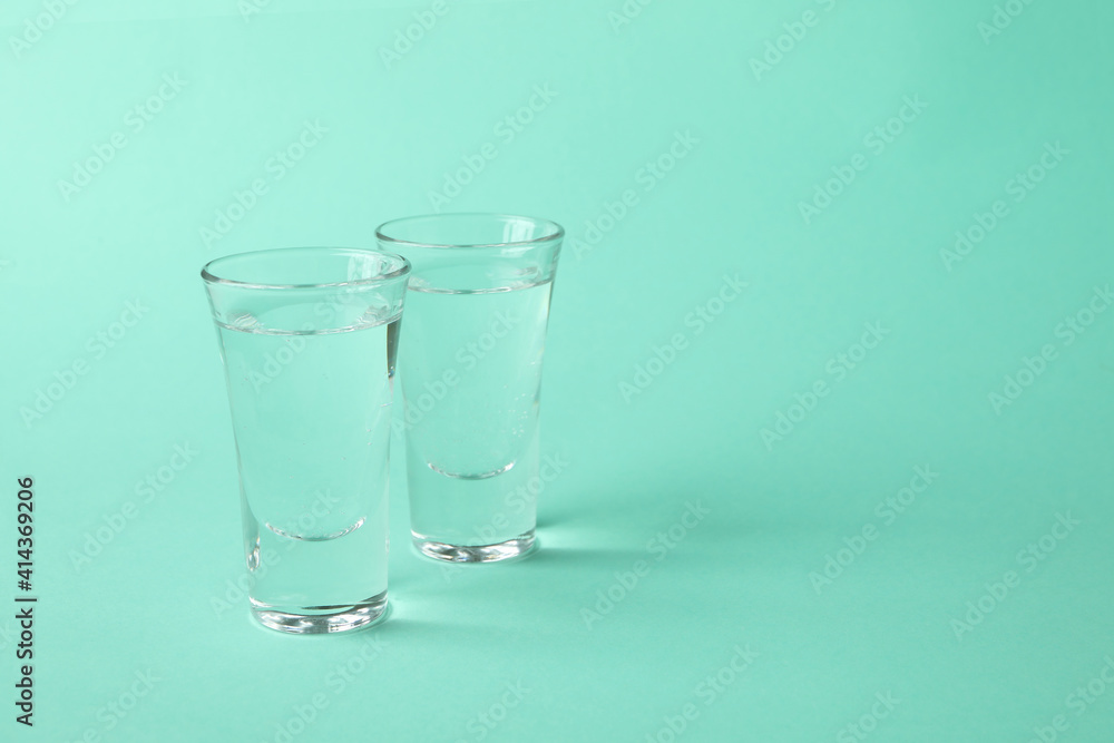 Shots of vodka or tequila on mint background Shots of vodka or tequila on mint background