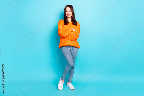 Full size portrait of pretty cheerful girl folded hands wear oversized pullover isolated on blue color background