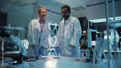 Female and Male Medical Industry Scientists Have Conversation and Use Futuristic Augmented Reality Technological Interface in Modern Science Laboratory photo