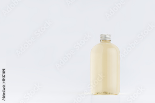 Transparent plastic low thick bottle with pale fresh drink or cosmetic essential oil with silver cap mockup on white background, template, copy space.