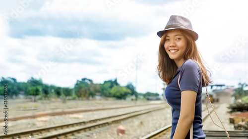 happy asian woman go to travel in sunny day at railway