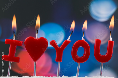 red burning candles making 'I love you' isolated. photo